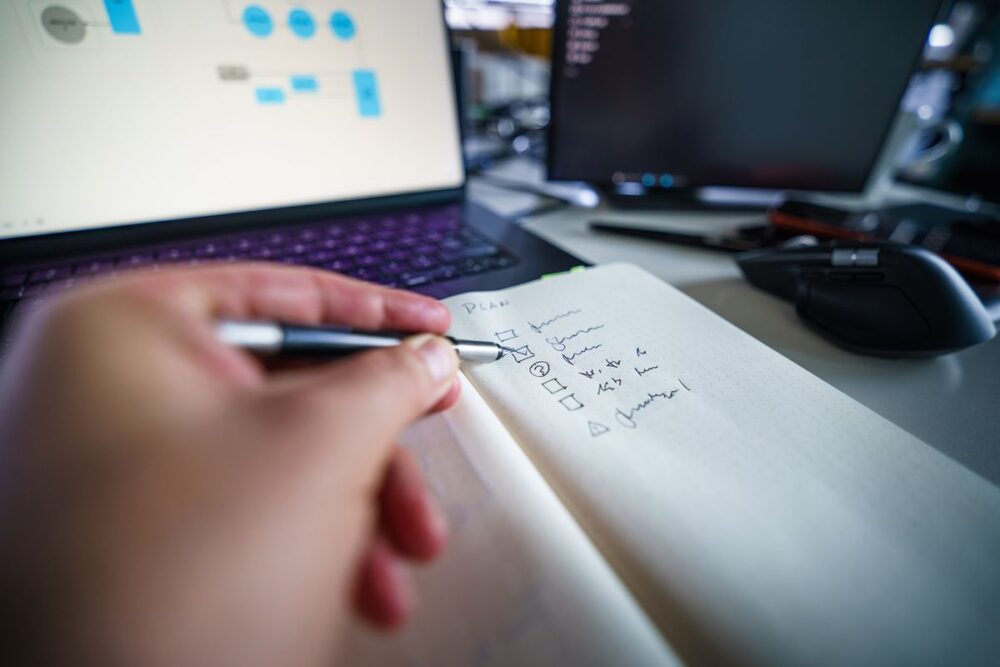 ノートに手書きでメモをする場面