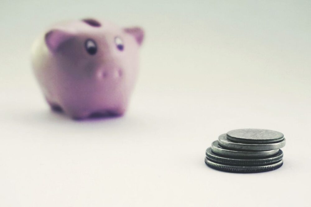貯金箱とコイン、医療費に備える貯蓄のイメージ